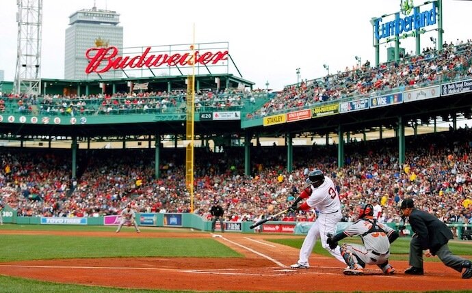David Ortiz of the Boston Red Sox swings at a pitch from home plate at Fenway Park as thousands of fans watch from the stands